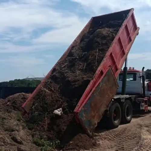 Cigna dump truck unloading soil at a work site