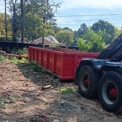 Cigna roll-off truck placing a dumpster at a wooded job site
